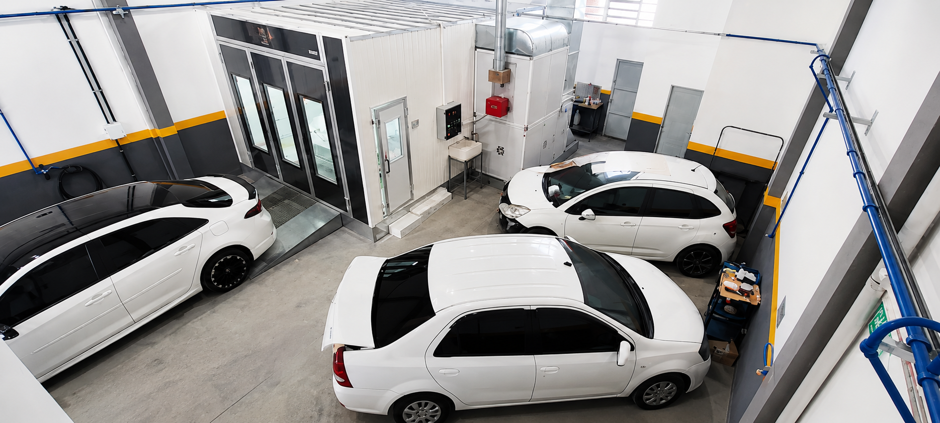 Oficina da Fercar Reparação Automotiva em Porto Alegre com cabine de pintura e veículos em atendimento